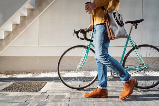istock Side view of an unrecognizable modern man walking with his bicycle 1310341358