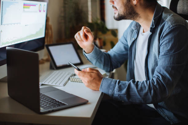 istock Young man using desktop pc at desk in home office 1310342587