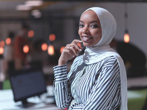 african muslim businesswoman portrait wearing hijab at creative modern startup coworking open space office