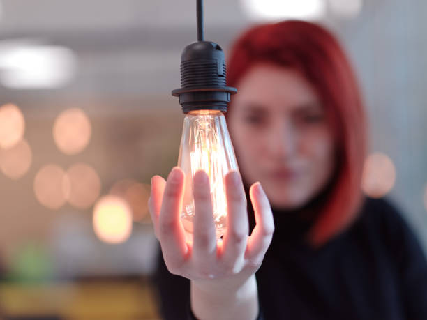istock businesswoman holding hand around light bulb 1310350297