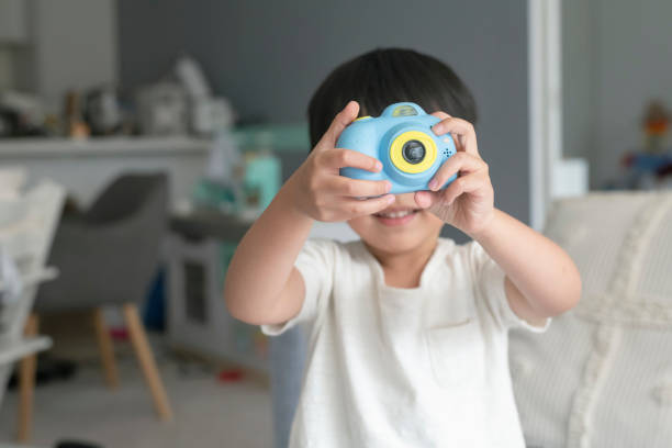 istock Cute toddler boy playing with toy camera 1310351520