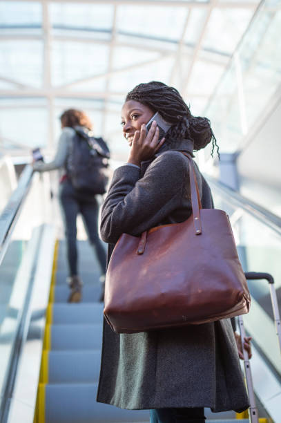 istock Ethnic Businesswoman Riding Escalator 1310352308
