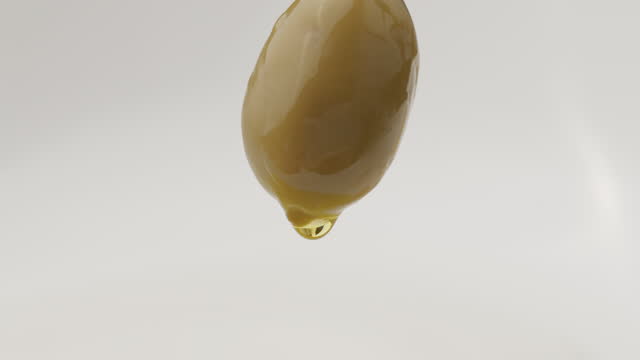 Olive oil is dropping down from olive. Close-up green olive.
Olive Splashing into Olive Oil. putting virgin olive oil on olives in nest of olive branches isolated on white background isolated on white background. Close-up green olive