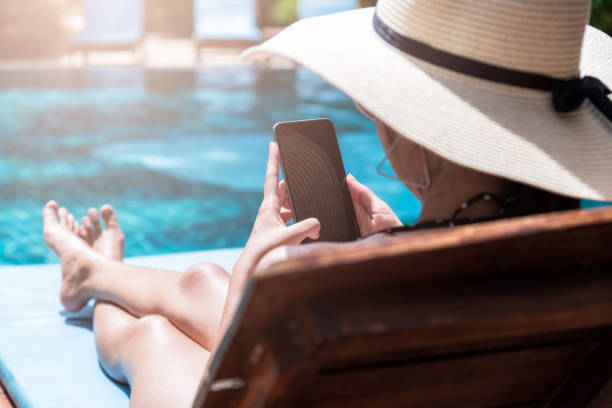 hermosa mujer mujer feliz usar teléfono inteligente relajarse cerca de la piscina - swimwear bikini swimming pool red fotografías e imágenes de stock
