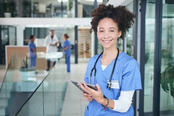 Technology helps the day run smoother Cropped portrait of an attractive young nurse standing and using a digital tablet in the clinic assistant stock pictures, royalty-free photos & images