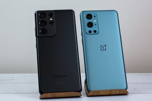 OnePlus 9 Pro 5G in Pine Green next to Samsung S21 Ultra 5G in Phantom Black. Manhattan, New York, April 2021.