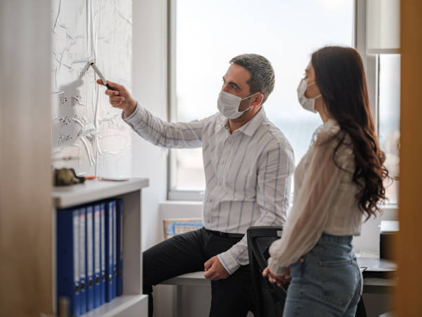 istock Business People With Protective Face Mask Discussing 1310377662