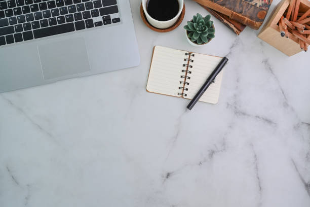 istock Stylish working table with laptop computer, notebook and stationery on marble background. 1310382649