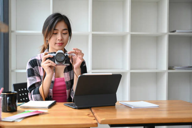 istock Charming female photographer or checking photo on her camera and working with computer tablet at creative office. 1310382685