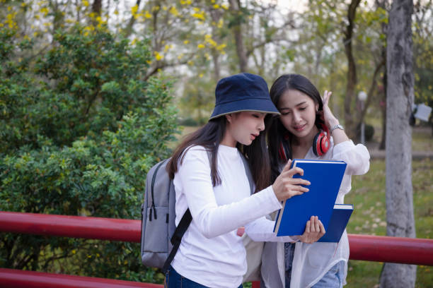 istock Two college students standing in corridor and talking each other after their class. 1310382778