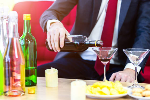 close up of a business suit of man pouring champagne into glass on xmas and the new years eve party,party after work concept - printers ornament imagens e fotografias de stock