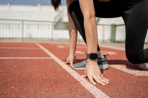 istock Runner in a stadium is in start position with hands on the line. Hands on starting line. 1310384411