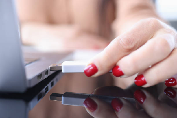 female hand inserting usb flash into laptop closeup - office tool flash imagens e fotografias de stock