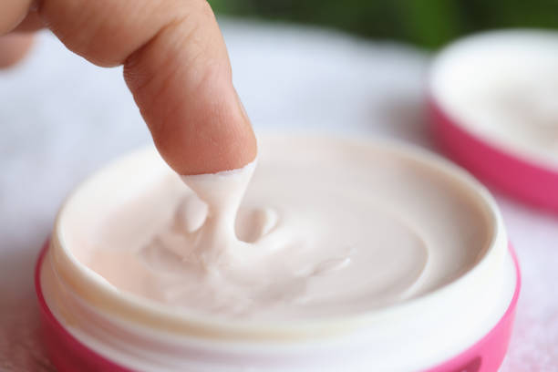 Man taking out nourishing cream from jar closeup. Skin care concept