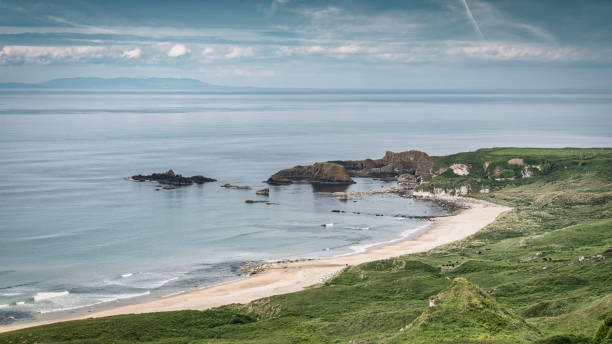 Portbradden Dunseverick Coastal Beach Panorama. Scenic view to the natural coastal beach between Dunseverick Harbour and Portbradden Harbour. Sunny view over the Atlantic Ocean in Summer. Dunseverick - Portbradden, Antrim County, Northern Ireland, UK, Europe