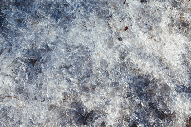 istock Small dirty broken ice on the ground. The beginning of spring. Broken ice on the ground as a background. Winter 1310388552