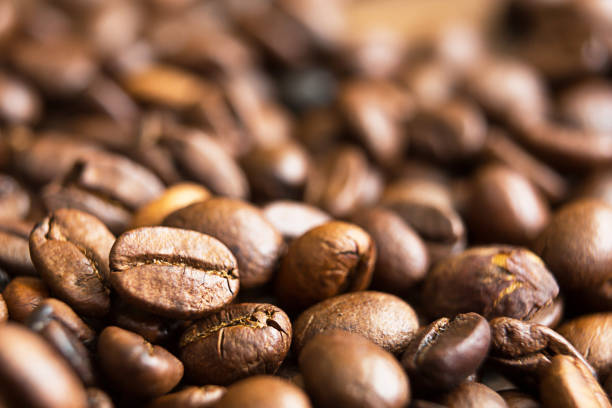 istock Roasted coffee beans close - up-fragrant background. Brown arabica coffee beans are scattered on the wooden table. Copy space 1310388607