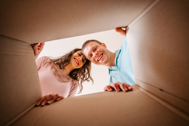istock Couple unpacking cardboard box together 1310389429