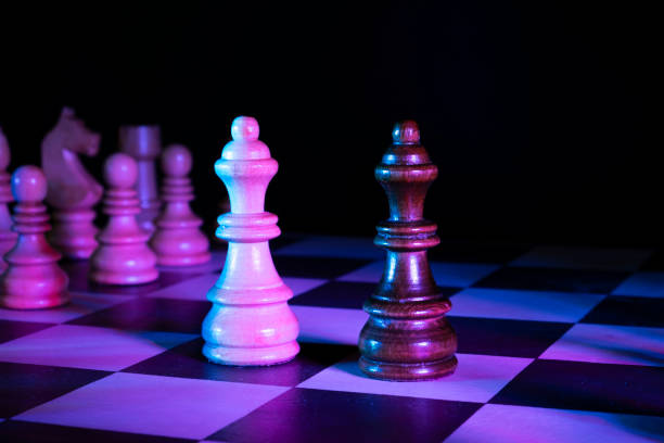 istock Queen chess figures on a chessboard. Dark background, neon studio lights 1310389617