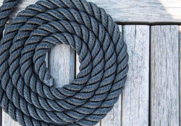 istock Coiled mooring line on wooden pier. Nautical style. 1310391579
