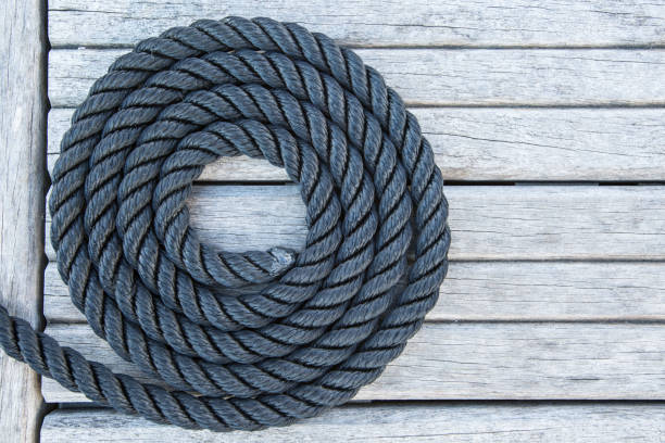 istock Coiled mooring line on wooden pier. Nautical style. 1310391584