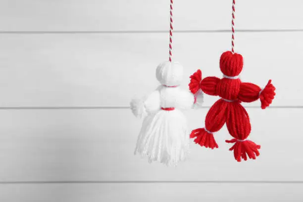 Traditional martisor shaped as man and woman on white background, space for text. Beginning of spring celebration