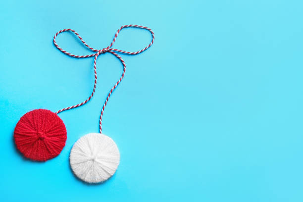 Traditional martisor on light blue background, top view with space for text. Beginning of spring celebration