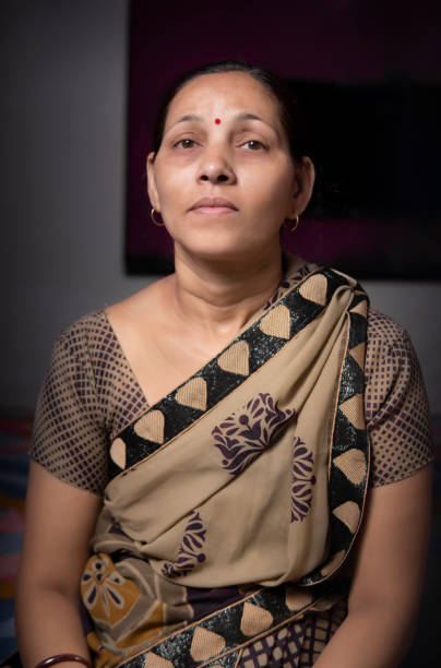 istock Serene Indian woman in sari looks at the camera with a blank expression. 1310394366