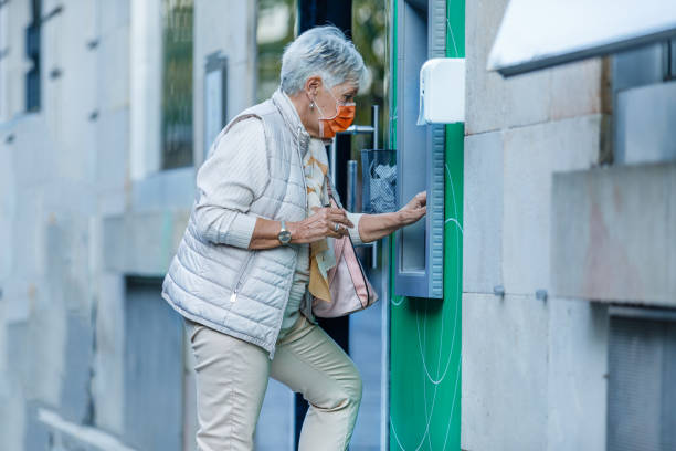 istock Senior Woman is Using ATM During a Pandemic Time. 1310395544