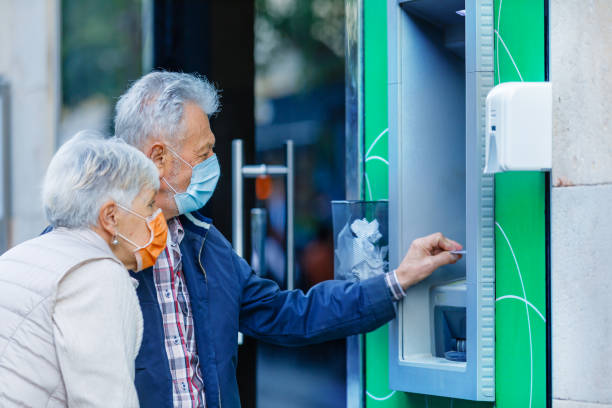 istock Senior Couple with Face Masks is Using an ATM Machine. 1310395557