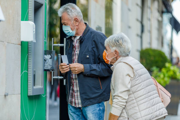 istock Senior Couple is Using ATM During a Pandemic Time. 1310395672