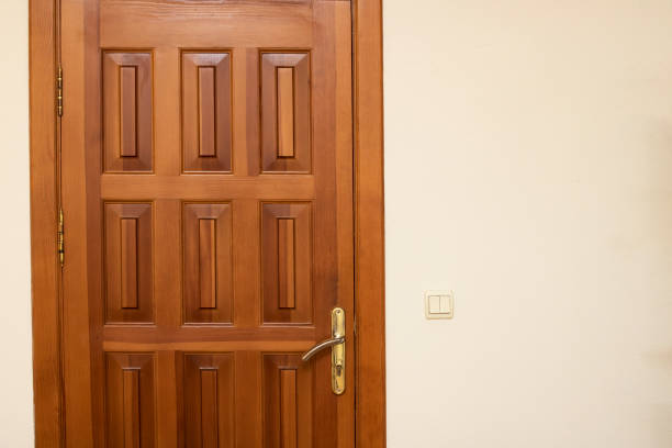 istock Wooden door on white wall close up 1310396598
