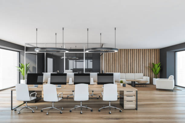 istock Wooden office room with white armchairs and table with computer 1310397977