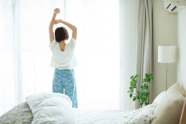 自宅で過ごす若い女性 - arched window ストックフォトと画像