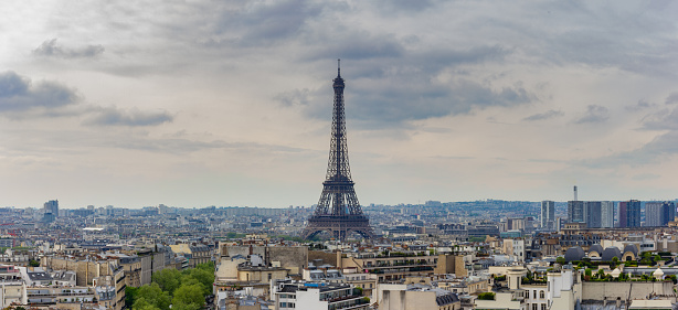 A panorama picture of the Eiffel Tower overlooking the nearby rooftops of Paris.