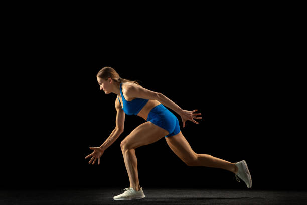 istock Active woman, track athlete training isolated over black studio background. 1310399448