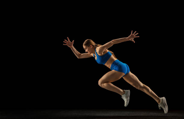 istock Sportive woman, track athlete training isolated over black studio background. 1310399464