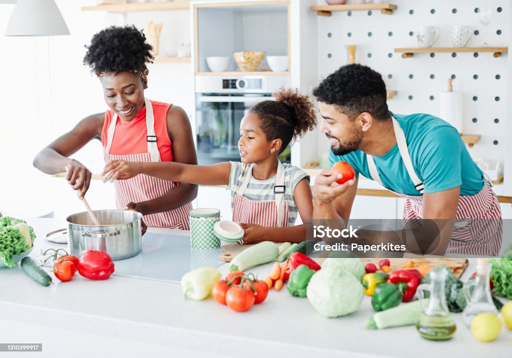 family child kitchen food daughter mother father cooking preparing breakfast  happy together Family preparing meal and having fun in the kitchen at home Family Stock Photo