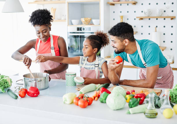 family child kitchen food daughter mother father cooking preparing breakfast  happy together Family preparing meal and having fun in the kitchen at home family dinners and cooking stock pictures, royalty-free photos & images