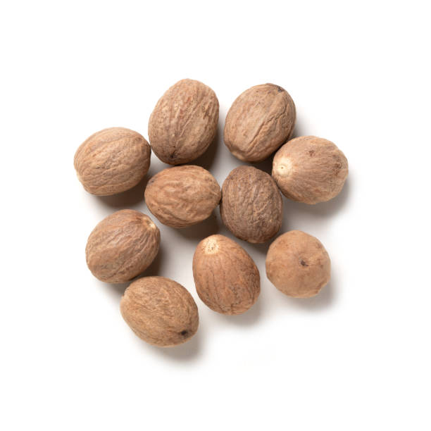 семена мускатного ореха - куча цельного ароматного мускатного ореха, ароматная специя аромата - nutmeg стоковые фото и изображения