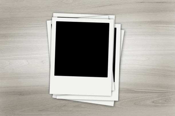 istock Stack of old instant photos at grunge wooden background 1310402985