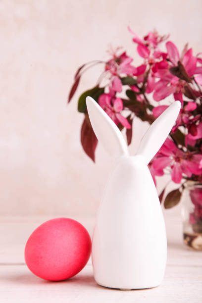 statuetta di coniglietto pasquale accanto all'uovo dipinto - figurine easter egg easter holiday foto e immagini stock