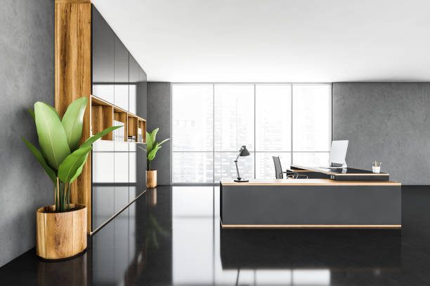 istock CEO office interior with a wooden table, a computer standing on it. Black floor. Big plants. 3d rendering. Panoramic city view window 1310404062