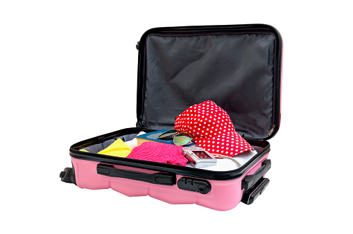 Abre maleta rosa con cosas para el resto, aislada en blanco. Bolsa de viaje familiar embalada para vacaciones. Equipaje lleno de ropa, concepto de viaje photo