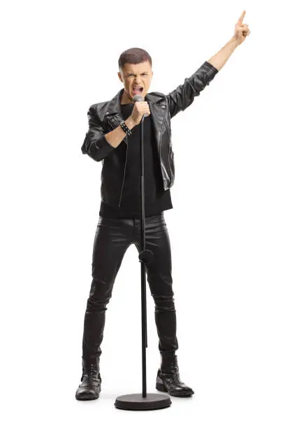 Full length portrait of a male teenage singer with a microphone isolated on white background