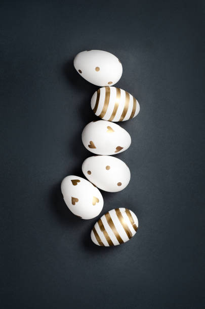 istock Top view on white and golden Easter eggs on dark background 1310407539