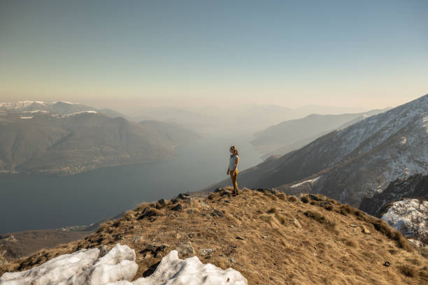 istock Hiker female on mountain top contemplates the scenery 1310407633