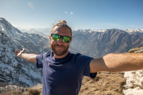 istock Cheerful young man taking a selfie portrait on mountain top 1310407660