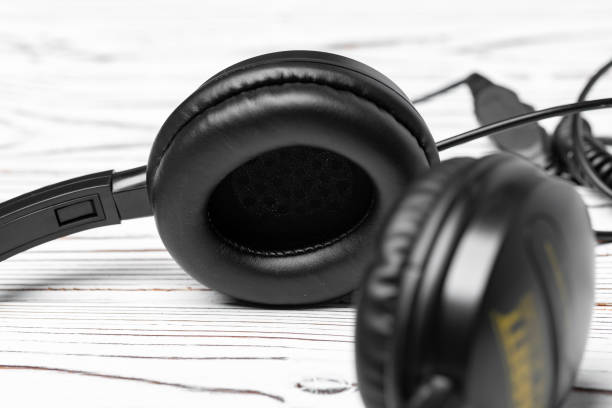 istock Black headphones with wire on wooden background 1310407702