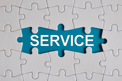 Service written in the middle of jigsaw puzzle, blue background. Horizontal composition with enough copy space for your text.